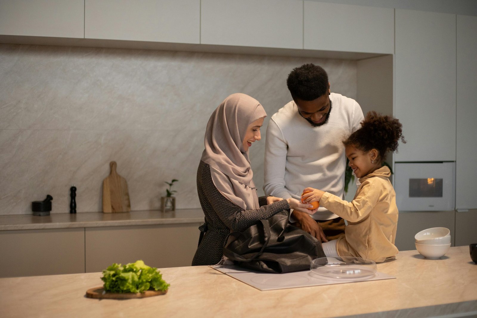 A joyful family of three preparing a meal together indoors, embracing diversity and happiness.